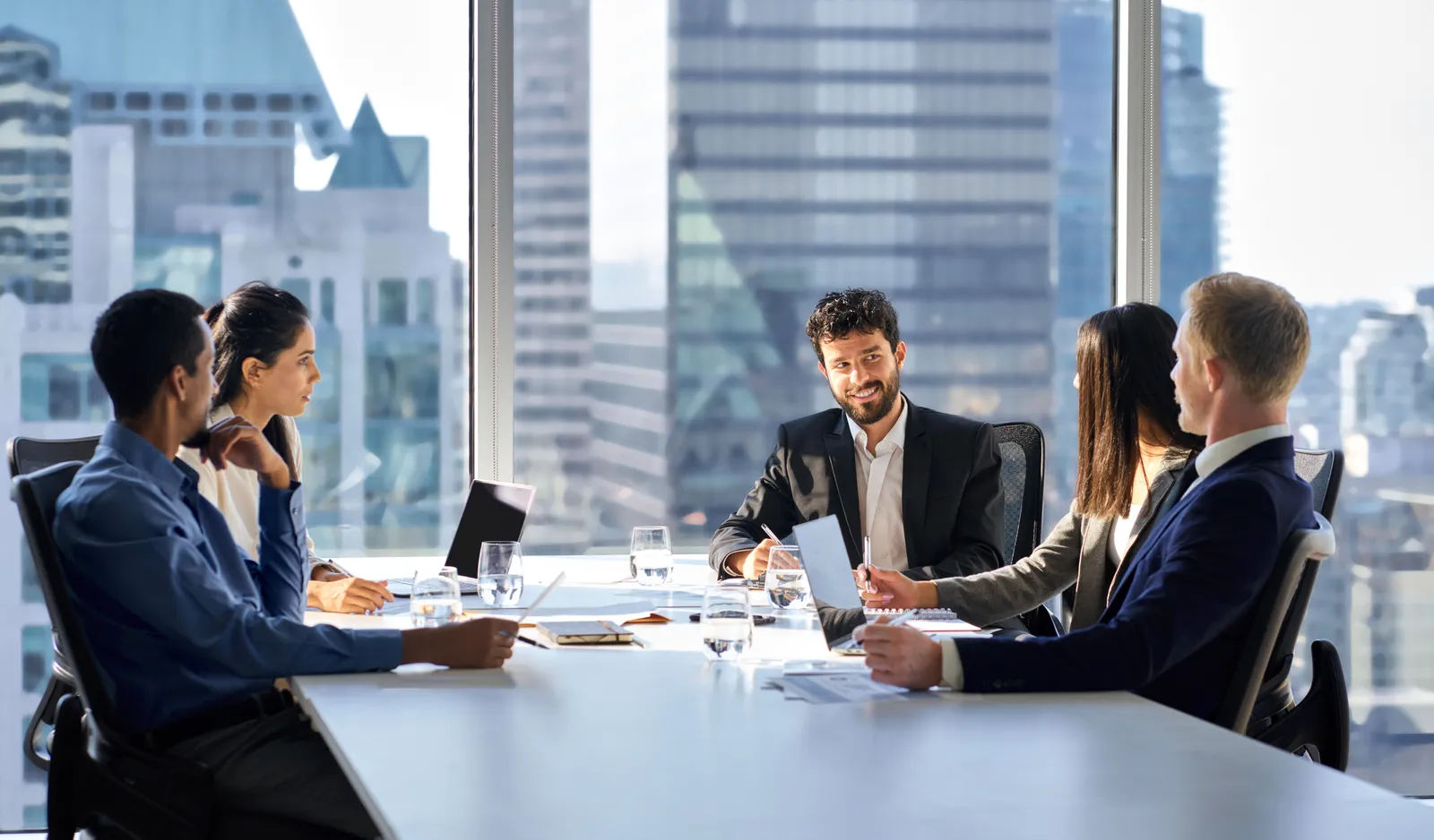 Colleagues talking around a boardroom table during a meeting
