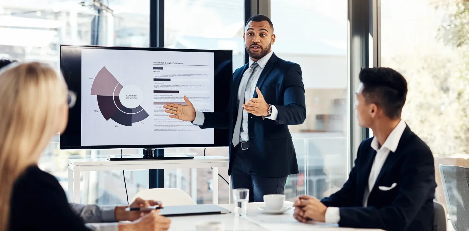 A senior manager presenting to colleagues around a boardroom table