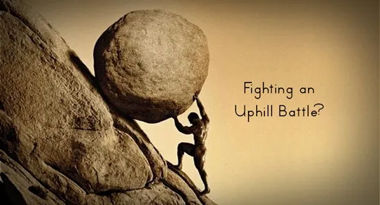 急な坂で大きな岩を押し上げる人と「Fighting an Uphill Battle?」の文字